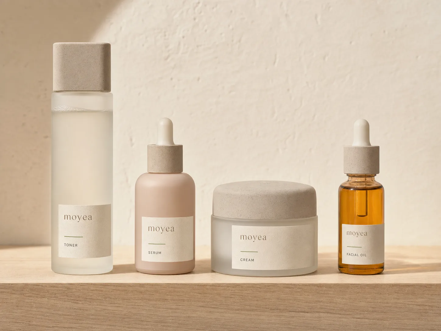 Four unbranded skincare products arranged from toner to facial oil on a wooden bathroom vanity
